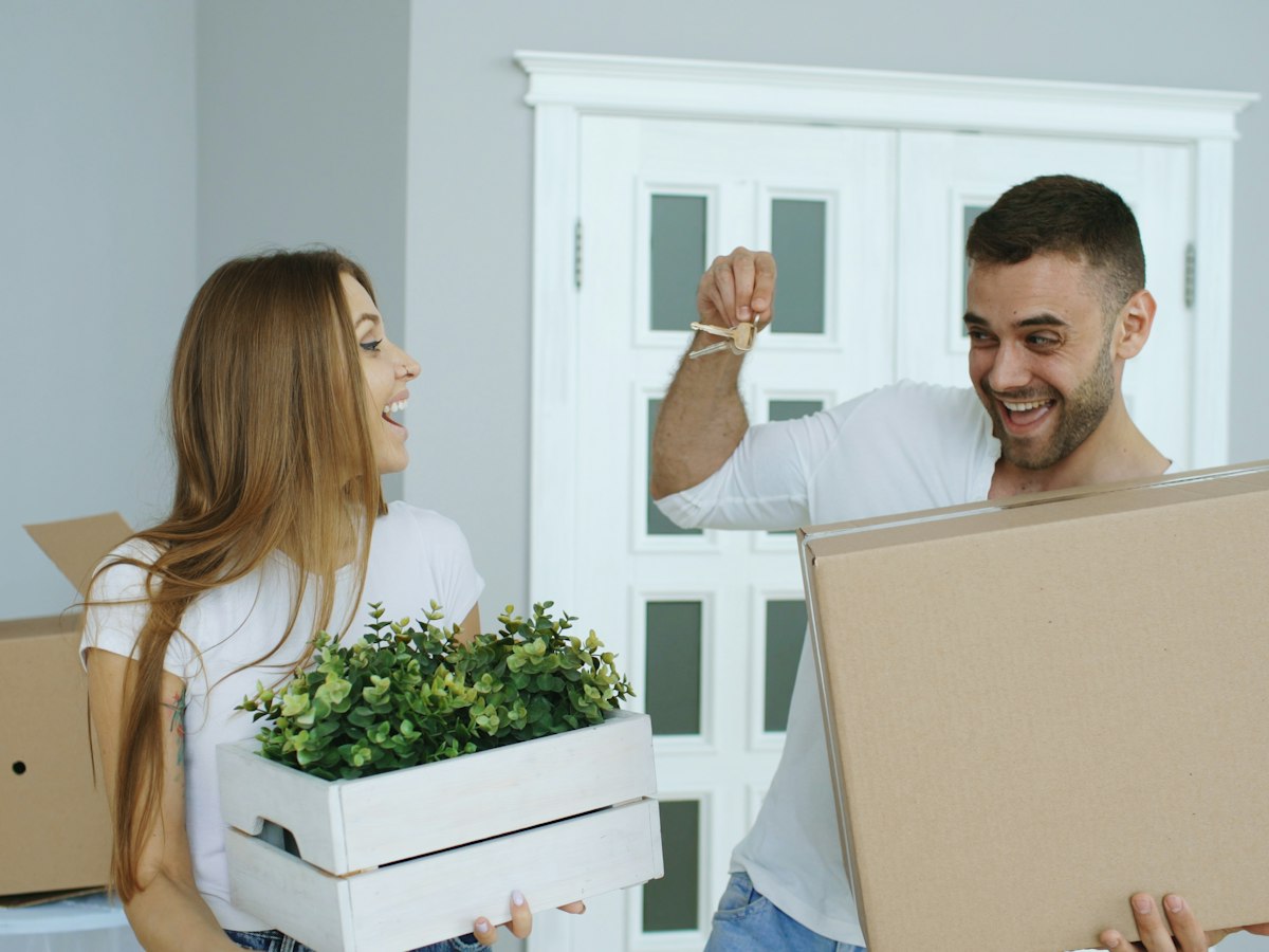 Couple souriant découvrant les clés d’un nouveau logement, photographie d’illustration